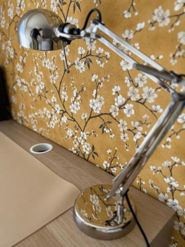 une lampe à motifs floraux sur un mur dans l'établissement Le Cosy Rionde : Apt 6 Prs, 2 ch, parking, clim, à Antibes