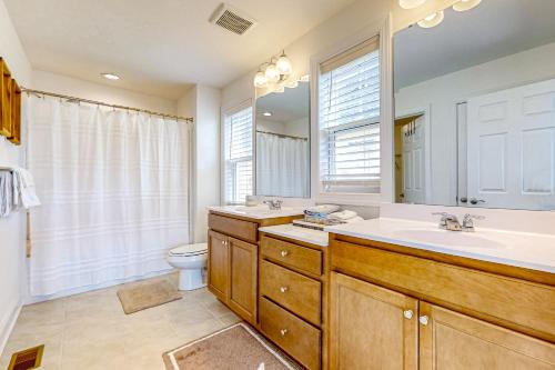 a bathroom with a sink and a toilet and a mirror at Marlin Chase --- 30266 Kona Dr in Ocean View