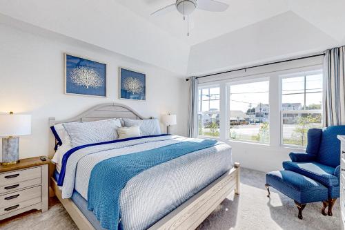 1 dormitorio con cama, silla azul y ventana en Marlin Chase --- 30266 Kona Dr, en Ocean View
