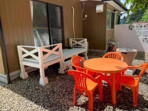 a patio with a table and chairs and a bench at Kojinjuku - Vacation STAY 46728v in Setouchi