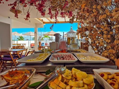 a buffet with many plates of food on a table at Porto Vila by AFT in Porto De Galinhas