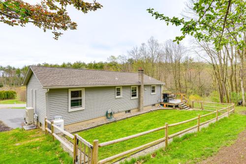 a house with a fence in front of a yard at Quaint Massachusetts Home with Yard and Grill! in Gill