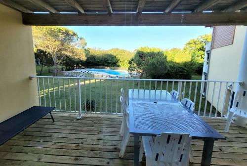 a table and chairs on a deck with a view of a pool at Appartement n°75 : 4-6 personnes plages à pied in Capbreton
