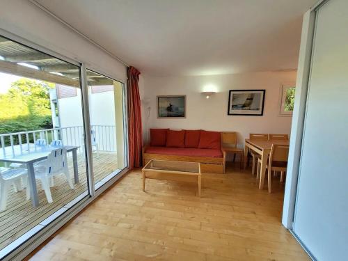 a living room with a red couch and a table at Appartement n°75 : 4-6 personnes plages à pied in Capbreton