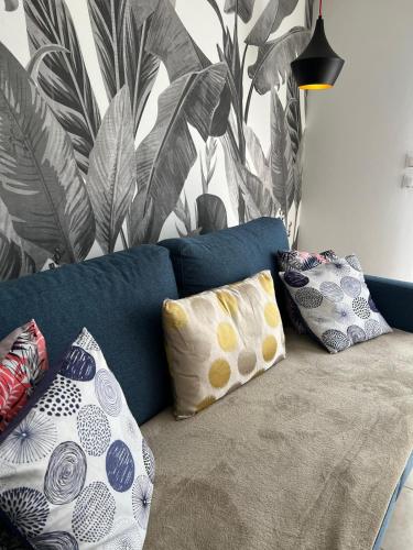 un canapé bleu avec des coussins dans un salon dans l'établissement Le Cosy Rionde : Apt 6 Prs, 2 ch, parking, clim, à Antibes