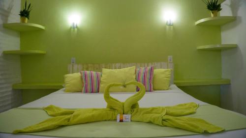 a bed with a towel shaped like a swan on it at Pousada La Luna in Paracuru
