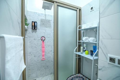 El baño incluye ducha con cabezal de ducha rosa. en The Skyline Stay, en Marrakech