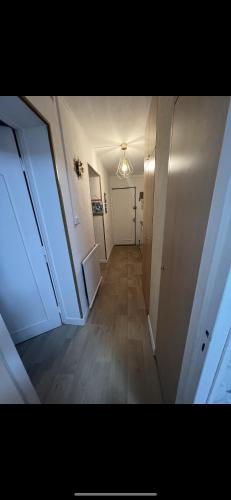 un couloir vide avec une porte blanche et un hallwayngth dans l'établissement Florange proche luxembourg, à Florange