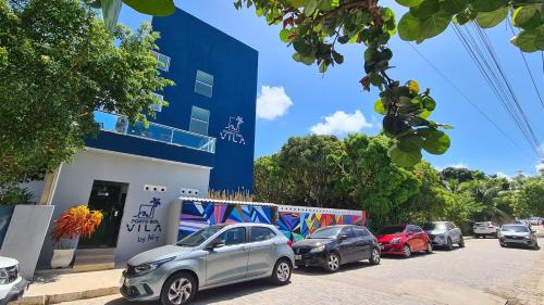 una fila de autos estacionados frente a un edificio en Porto Vila by AFT, en Porto de Galinhas