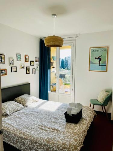 une chambre avec un lit avec une chaise et une fenêtre dans l'établissement Bel appartement au calme et très bien situé !, à La Ciotat