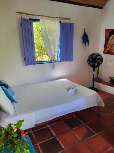 a bed in a room with a window at Chalé Flor do Ser in Canoa Quebrada