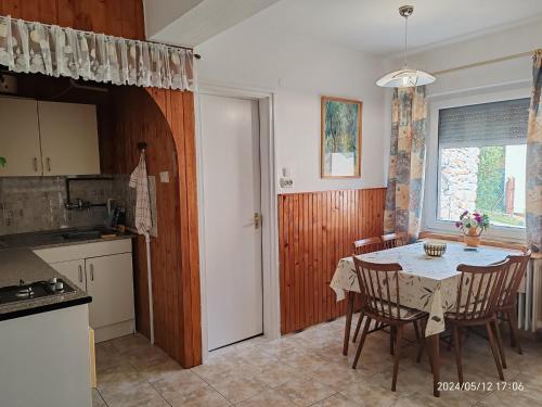 a kitchen and dining room with a table and chairs at Panoráma Holiday Home in Badacsonyörs