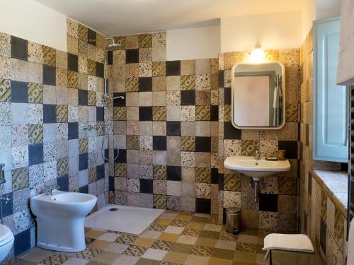 a bathroom with a toilet and a sink and a mirror at I Casali del Pino in La Giustiniana