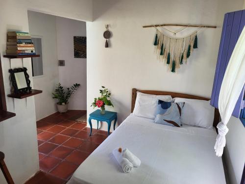 a bedroom with a bed and a blue table at Chalé Flor do Ser in Canoa Quebrada