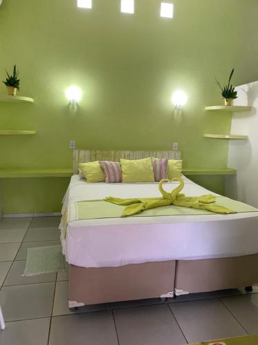 a bedroom with a bed with a yellow ribbon on it at Pousada La Luna in Paracuru