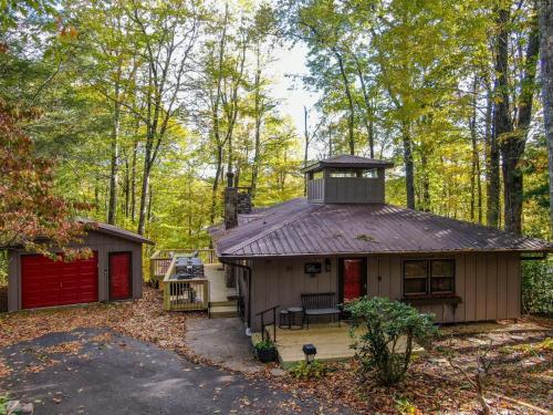 a cabin in the woods with a red garage at Blue Ridge Retreat at Linville Land Harbor in Newland