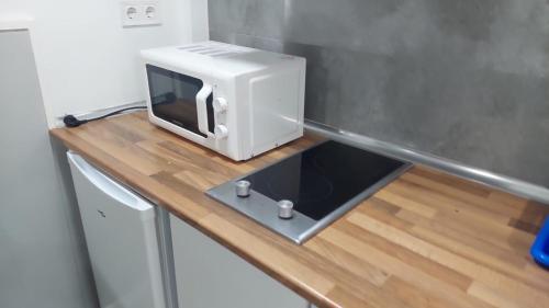 a microwave sitting on top of a wooden counter in a kitchen at Estudios sol in Madrid
