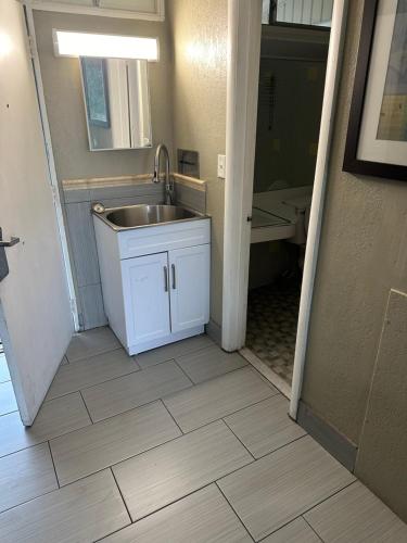 uma cozinha com lavatório e uma casa de banho com banheira em Bravo Inn Greensboro em Greensboro