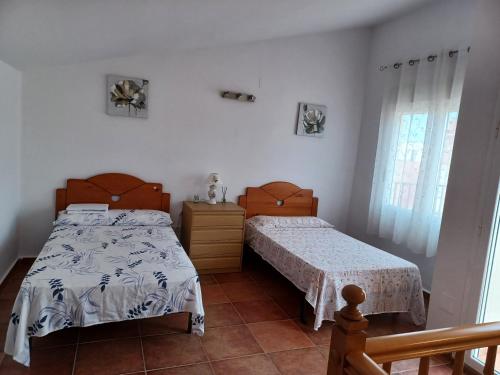 Un dormitorio con dos camas y una ventana. en CASA MUY CERCA DE LA PLAYA a, en Peñíscola