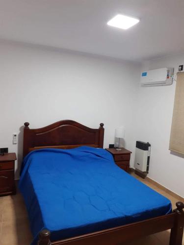 ein Schlafzimmer mit einem blauen Bett in einem Zimmer in der Unterkunft Amplio Dpto con 2 dormitorios primer piso independiente con asador in San Francisco
