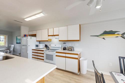 a kitchen with white appliances and wooden cabinets at Orca #14A-CAC in Buxton