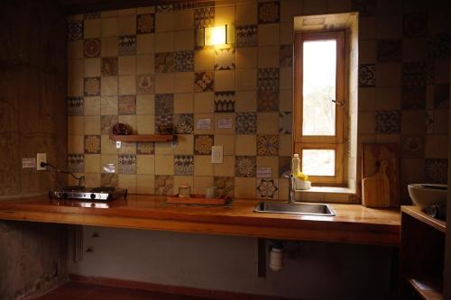 a kitchen counter with a sink and a window at Cueva Ancestral --Experiencia entre los cerros-- in Coronel Moldes