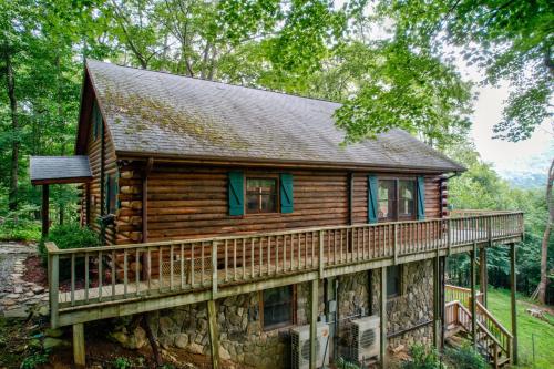 a log cabin with a wrap around deck at Banner Bunks at River Run in Banner Elk