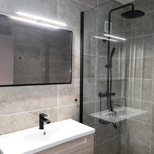 une salle de bain avec une douche avec un lavabo et un miroir dans l'établissement Résidence Les Carlines - 707 LES CARLINES 1650 MAE-2294, à Le Mélézet
