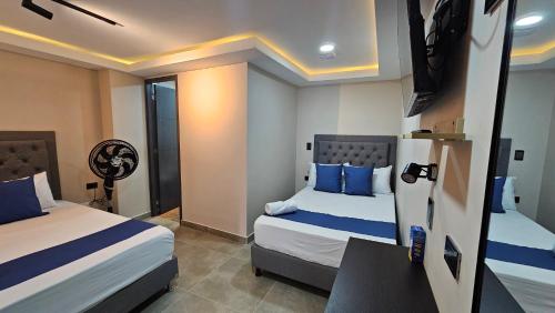 a hotel room with two beds with blue pillows at Andaliving Campo Valdés Estudio 102 in Medellín