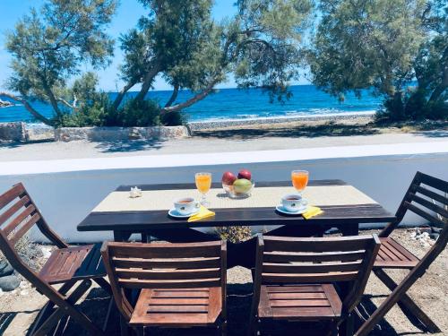 a table with two chairs and a table with fruit on it at Villa 33 in Monolithos