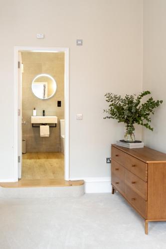 a bathroom with a sink and a cabinet with a potted plant at The Ballroom - Huge 2 Bed, Lichfield City Centre in Lichfield