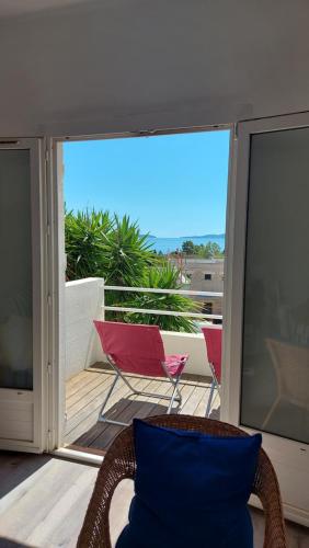un balcon avec une chaise et un oreiller bleu dans l'établissement Haut de villa Vue mer, au Lavandou