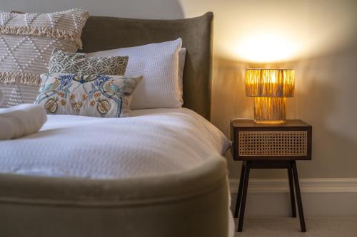 a bed with a lamp on a side table at The Ballroom - Huge 2 Bed, Lichfield City Centre in Lichfield