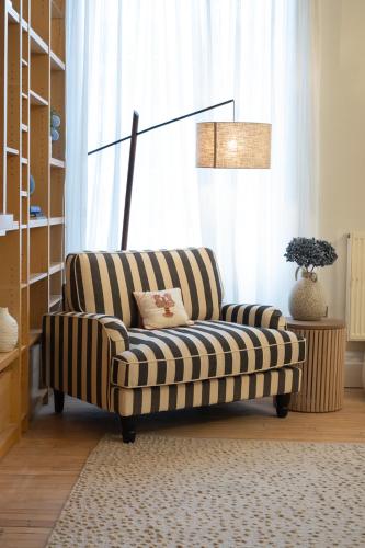 a striped couch in a living room with a lamp at The Ballroom - Huge 2 Bed, Lichfield City Centre in Lichfield