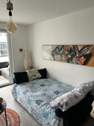 une chambre avec un lit et un tableau au mur dans l'établissement Charmant appartement proche du centre avec grande terrasse, à Strasbourg
