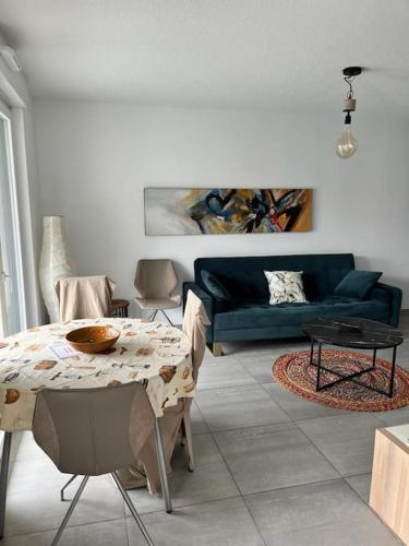 un salon avec un canapé bleu et une table dans l'établissement Charmant appartement proche du centre avec grande terrasse, à Strasbourg