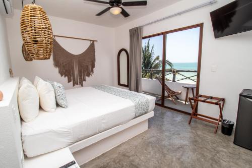 a bedroom with a bed and a balcony at HAU Holbox, Oceanfront Boutique Hotel in Holbox Island