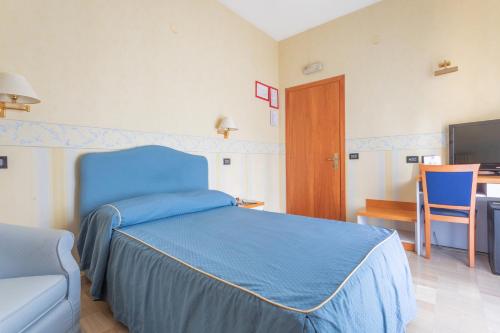 a bedroom with a blue bed and a chair at Hotel Touring in Falconara Marittima