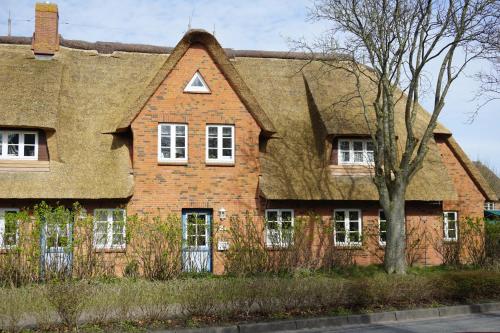 an old brick house with a shingled roof at Friisk Aran in Alkersum