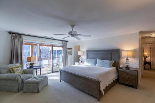 a bedroom with a bed and a chair and a window at Hinesight at Hound Ears in Valle Crucis