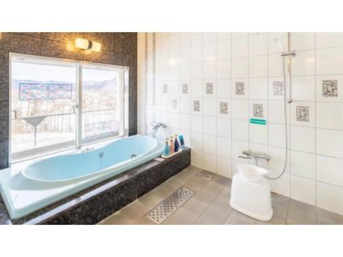 een badkamer met een blauw bad en een raam bij SHIZUKUISHI RESORT HOTEL - Vacation STAY 29563v in Shizukuishi
