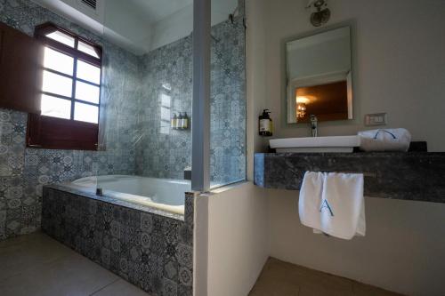 W łazience znajduje się wanna, umywalka i lustro. w obiekcie Artea Hotel Boutique w mieście Guadalajara