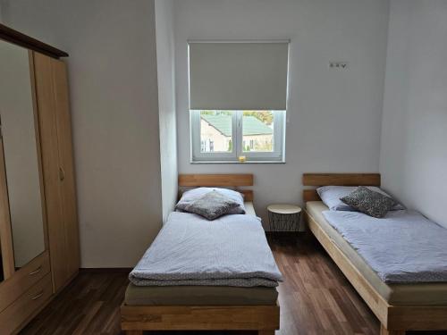 - 2 lits dans une chambre avec fenêtre dans l'établissement Wohnung mit 5 Zimmern für bis zu 10 Personen, à Amstetten