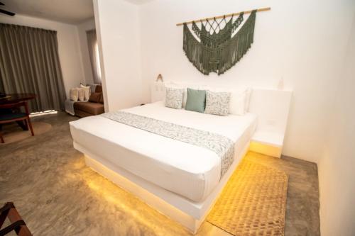 a bedroom with a large white bed in a room at HAU Holbox, Oceanfront Boutique Hotel in Holbox Island