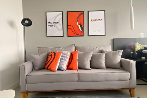 sala de estar con sofá y almohadas de color naranja en Morcelli Mobiliados - Uniqo Smart Living, en Santa Maria