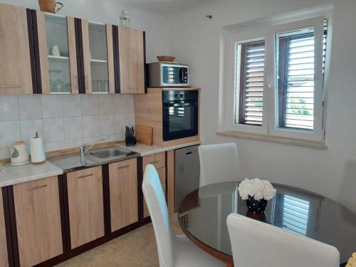 a kitchen with a table and chairs and a sink at Apartman Draga in Podstrana