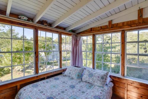 a bedroom with a bed in a room with windows at Oceanfront Cottage with Deck 2 Mi to Boothbay Harbor in West Boothbay Harbor