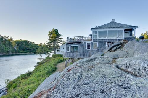 a house on a rock next to a river at Oceanfront Cottage with Deck 2 Mi to Boothbay Harbor in West Boothbay Harbor