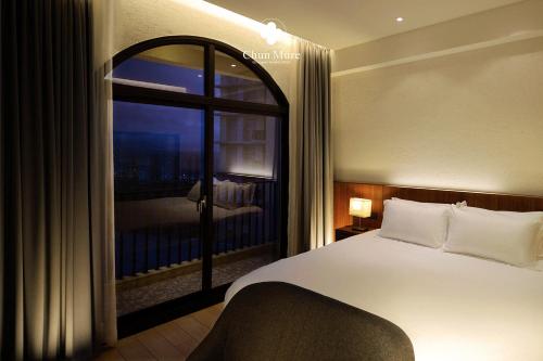 a bedroom with a bed and a large window at Chun Mure Hotel in Dahan