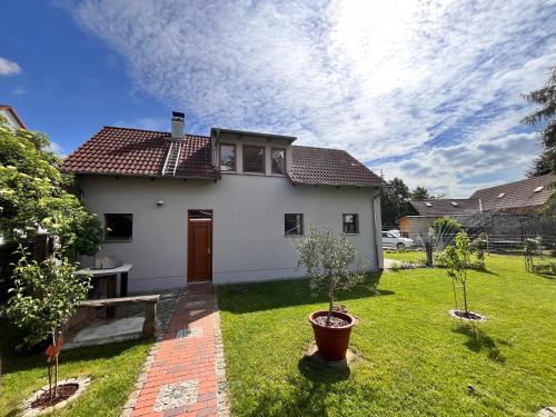 a white house with two trees in a yard at Ferienhaus Katharina in Hoyerswerda
